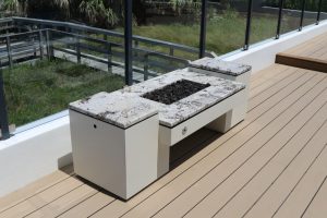 Natural gas powered deck fire pits with decorative glass