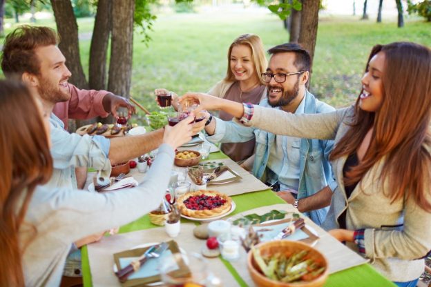 Friends having a Thanksgiving dinner outdoors.