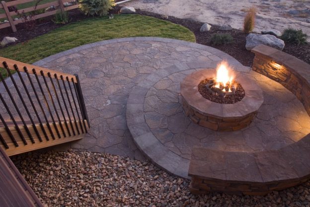 A stone firepit installed in a deck setting.